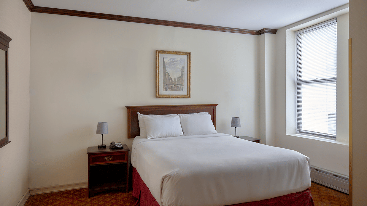 Room at Night Hotel Broadway showing a bed, framed wall art, and window near the corner.