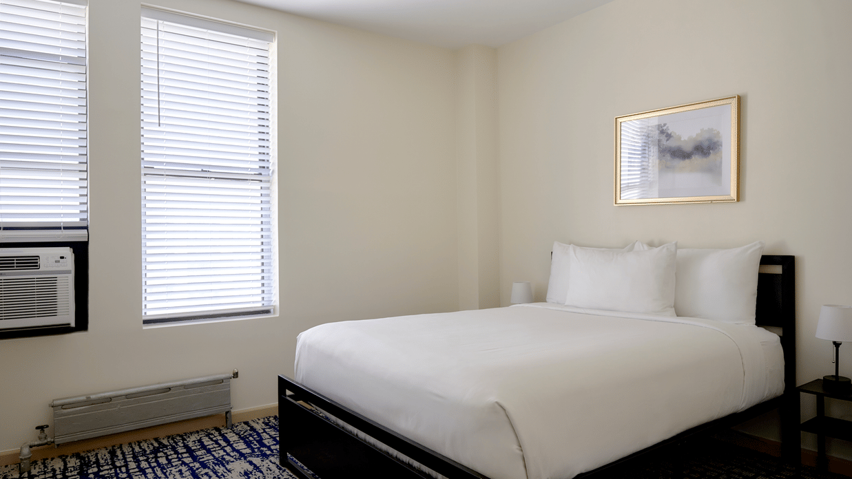Night Hotel Broadway room with single bed, two windows, framed wall art, and carpet floor.
