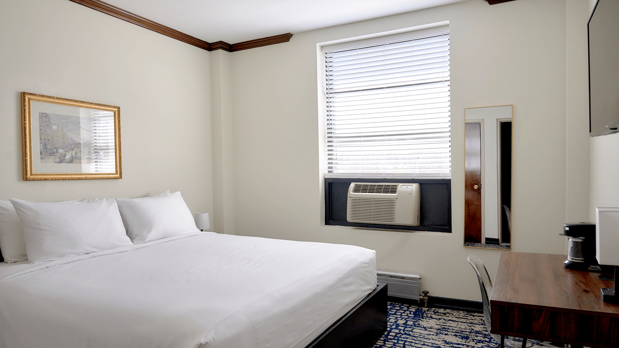 Guest room at Night Hotel Broadway with king bed, window, framed artwork, and carpet.