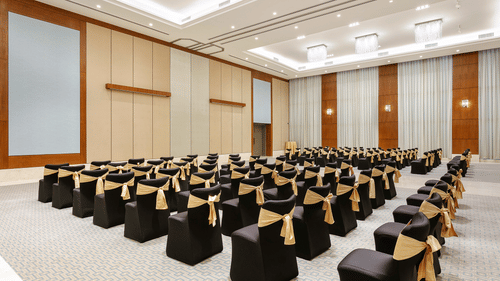 Theatre style seating arrangements inside the a banquet hall at Karma Lakelands set up for an event.
