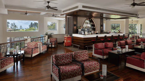 Seating arrangements inside Lobby Bar with sofas and a bar counter in view - Kenilworth resort & Spa, goa