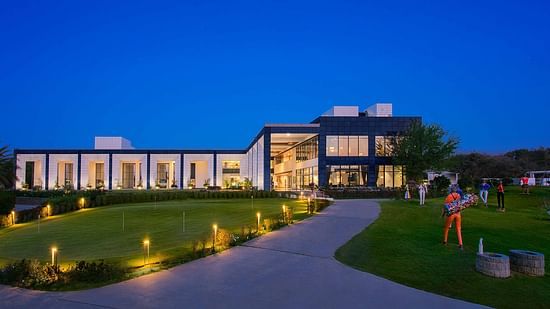 Facade of Karma Lakelands with green grass covering the pathway leading to the resort