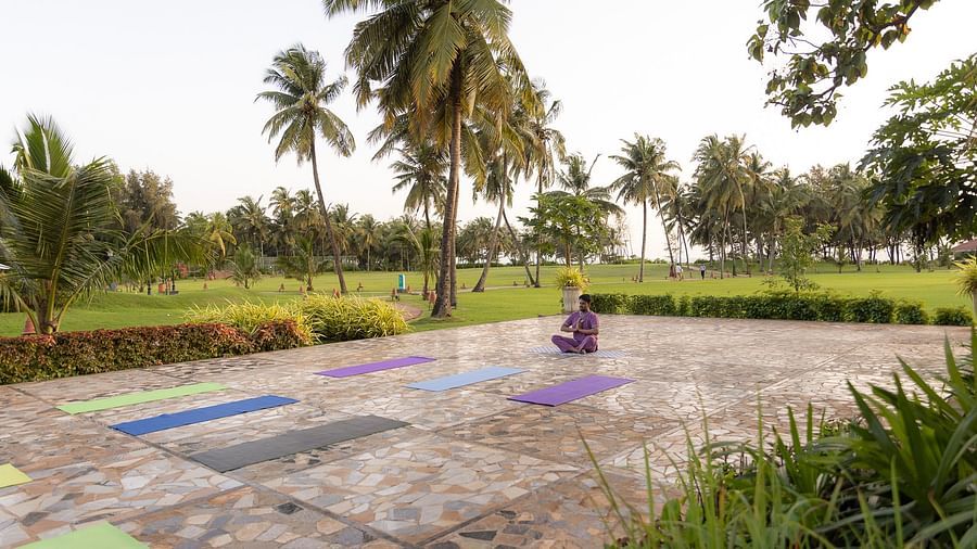image of a lush green lawn with tile pavement in the foreground at kenilworth resort and spa, goa