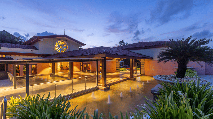 Facade view of the exterior of Kenilworth Resort and Spa, Goa, during twilight hour and the lights on.