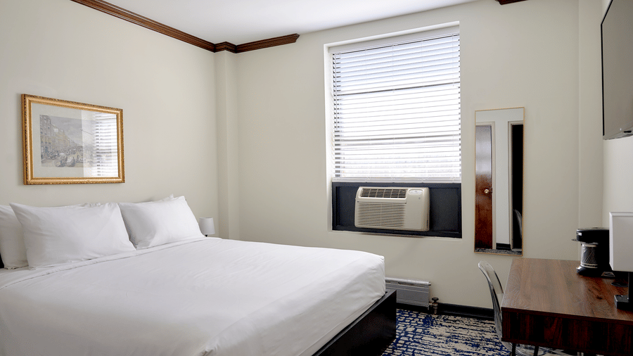 Guest room at Night Hotel Broadway with king bed, window, framed artwork, and carpet.