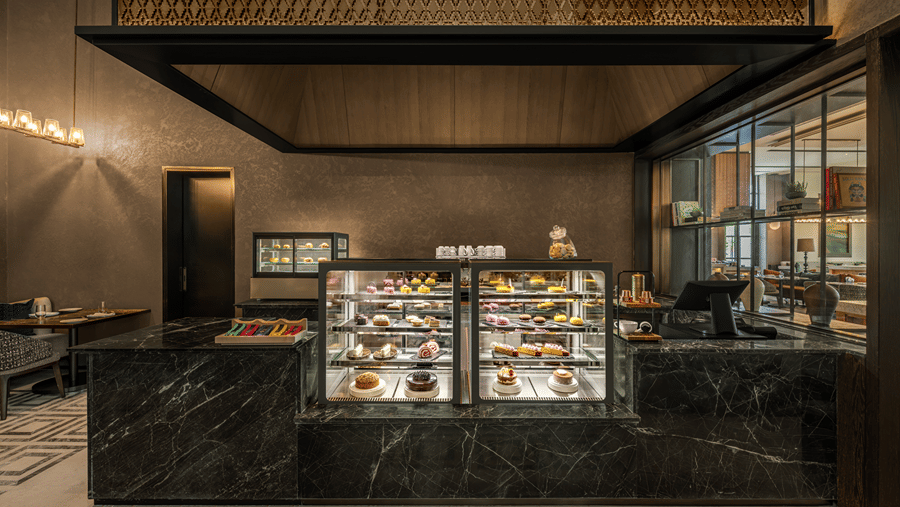 Krave counter with a glass display case and dark toned decor at The Residency Signature Madurai.