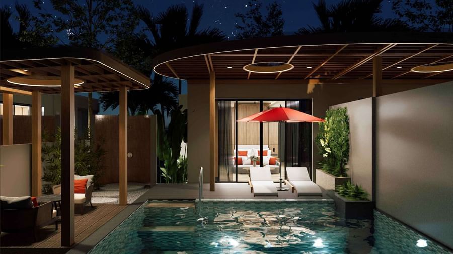 A nighttime view of the private pool villa at Ramada Resort by Wyndham Khao Lak, with the pool lit up and stars in the sky.