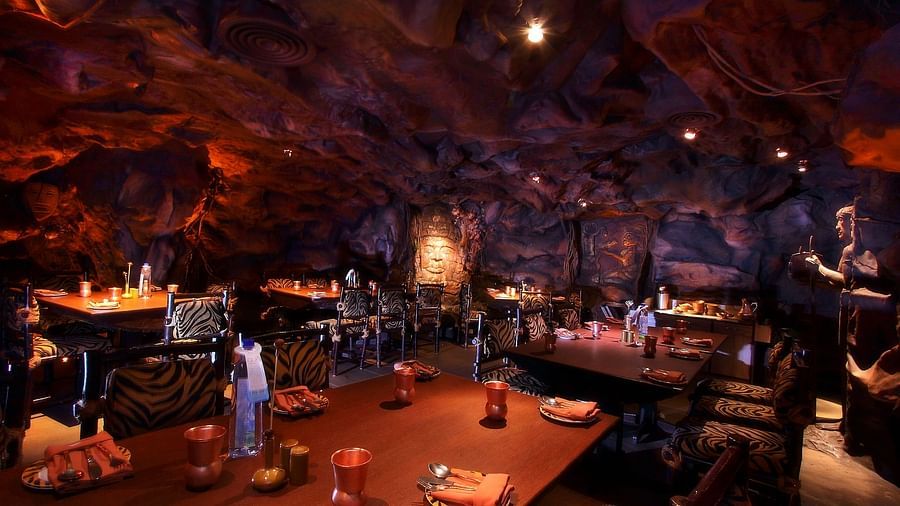 A thematic restaurant with a cave-like ambience, illuminated by soft lighting, creating an otherworldly dining experience - The President Hotel Jayanagar, Bangalore