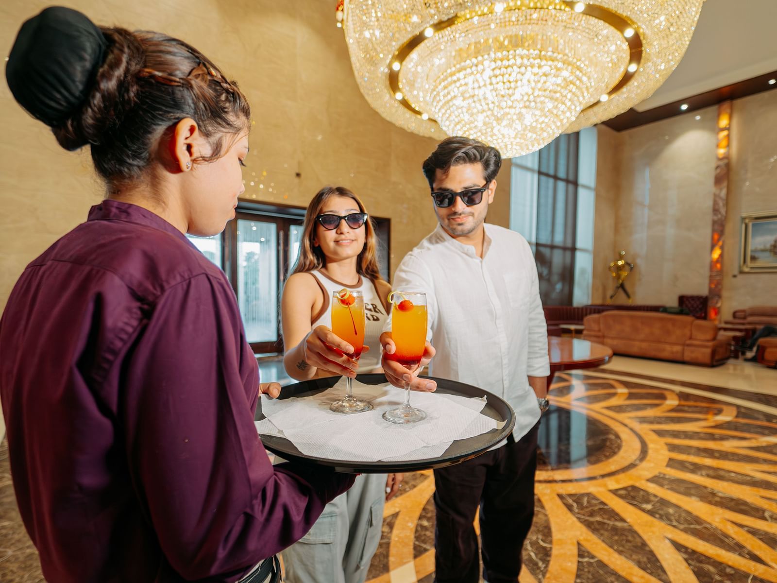 A couple receiving their welcome drinks as they enter the lobby area at Crescent Spa & Resort, Indore