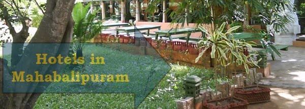 An outdoor seating area with benches and tables beneath trees with text 'Hotels in Mahabalipuram' written on the image and a building in the background.