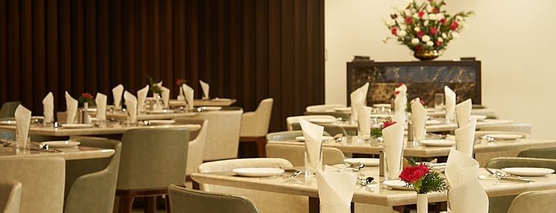 Variously arranged seating area at a restaurant at The Hamuse Hotel, Kodaikanal.