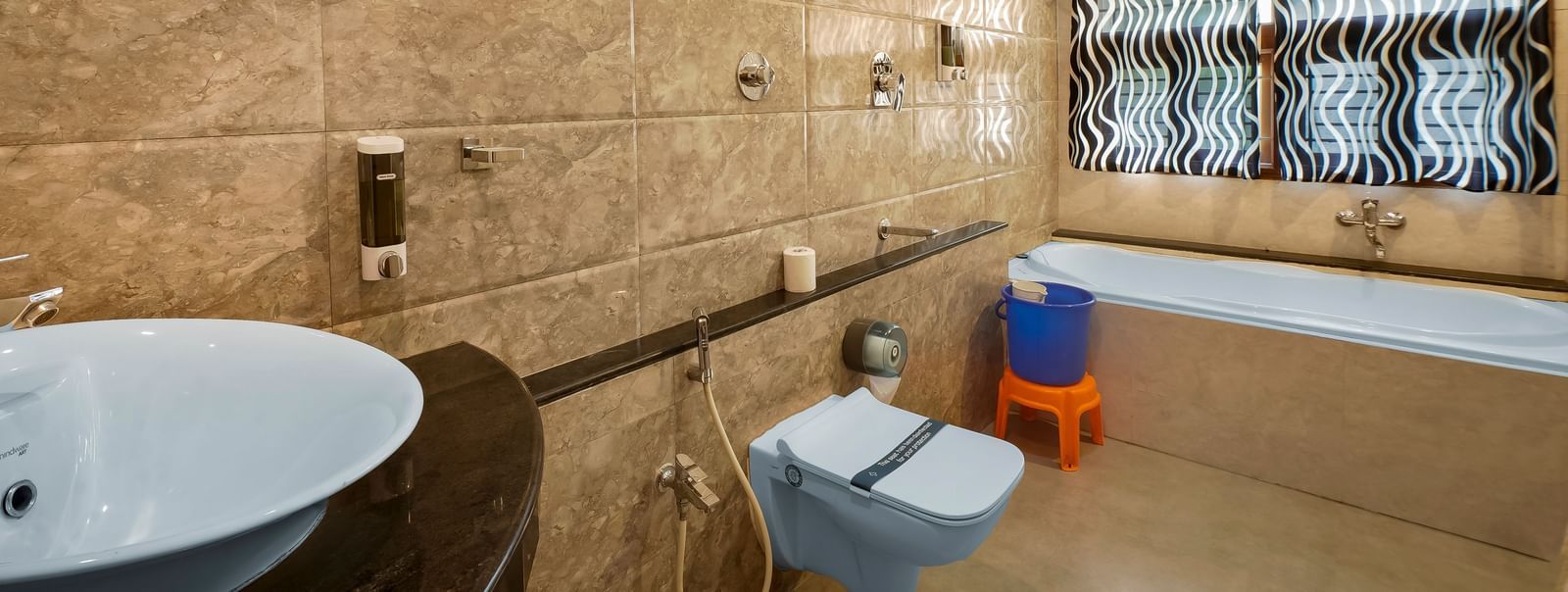 Modern bathroom with a bathtub, western toilet and a wash basin at WOW Bungalow, Yercaud.