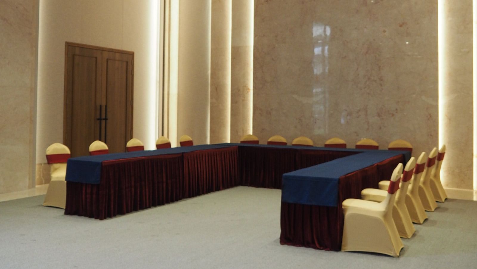 A U-shaped table arrangement in a modern, brightly lit conference space - Club Charholi, Pune 