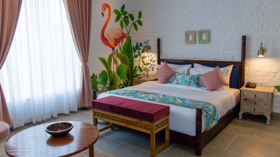 A king bed at The Sierra Udaipur featuring a futon at the base inside the Elite Room.