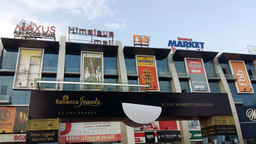 A lower angle view of the Himalaya Mall building, showcasing various flyers advertising different brands, creating a dynamic and engaging atmosphere.