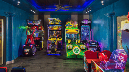 image of an indoor play area with a variety of arcade games in the room with blue coloured walls