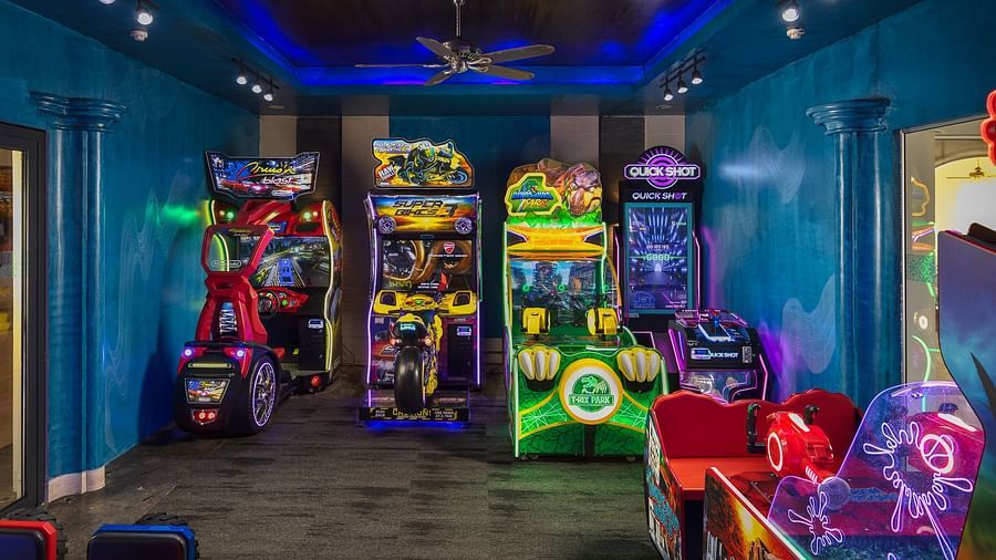 image of an indoor play area with a variety of arcade games in the room with blue coloured walls