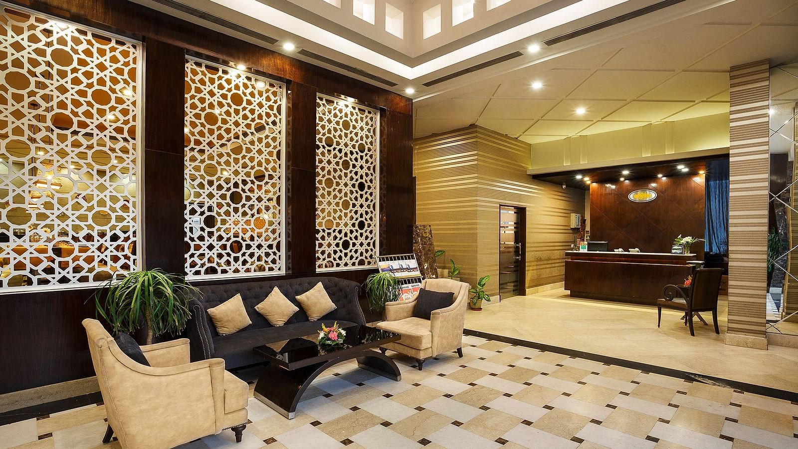 A sophisticated hotel lobby featuring a geometric patterned boards, plush seating, and a reception desk - The Manor, Bareilly