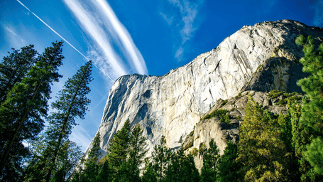 Majestic view of El Capitan's towering granite cliffs under a clear blue sky in the Yosemite National Park.