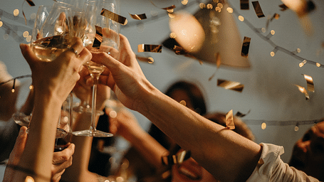 a group of people celebrating while clinking champagne glasses