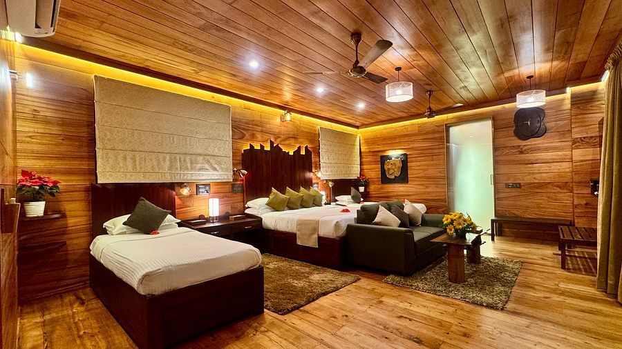 Wood-panelled interior of a room with a seating area and soft warm lighting - BluSalzz Collection - Tranquil Resort, Wayanad