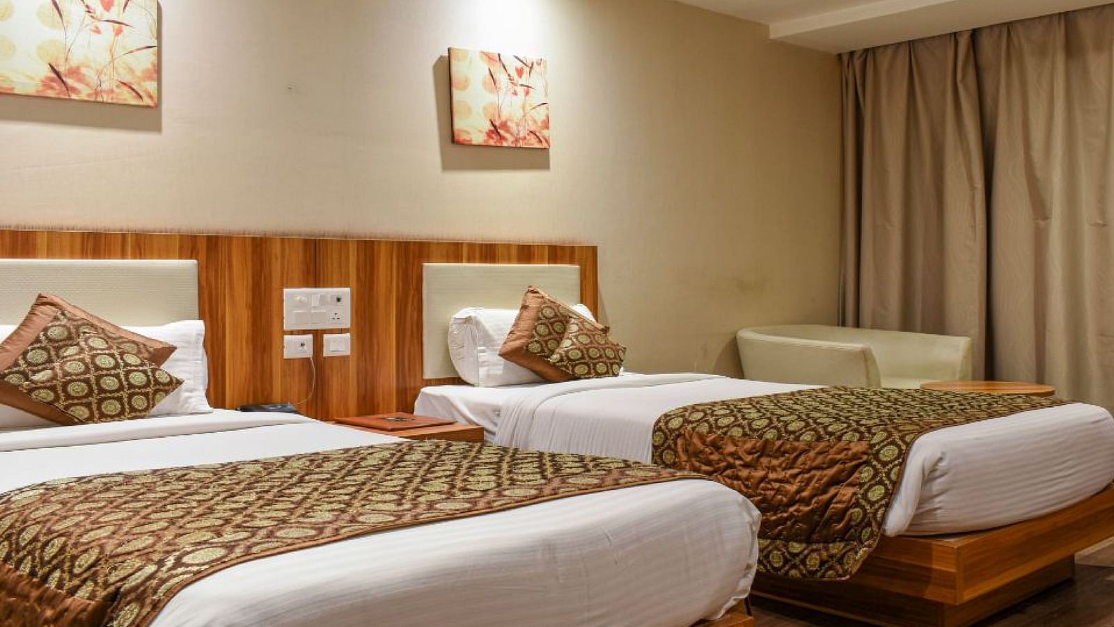 corporate room with twin beds and warm lighing at le roi raipur hotel