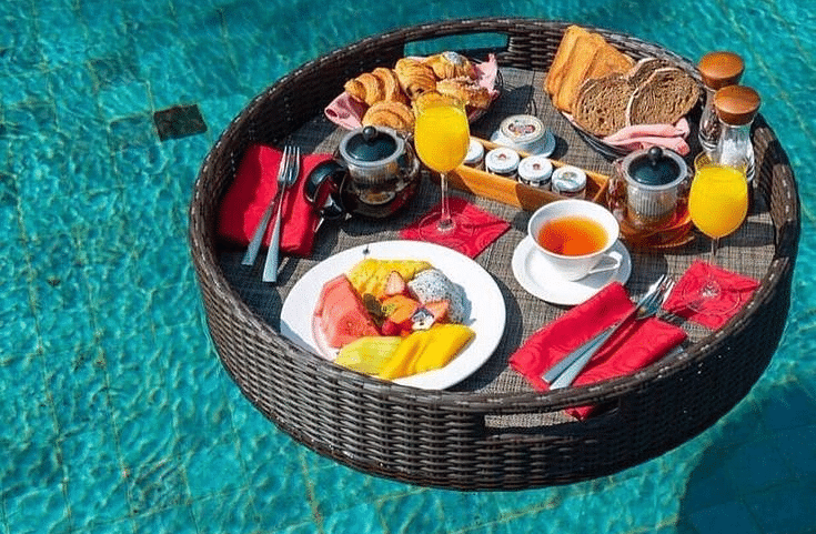 A tray floating on a water body with a variety of food placed on it at Valley by Grassfield.