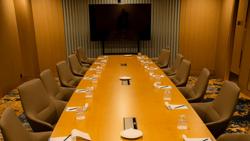 Wide-angle capture of modern conference hall with a wooden table, a projector, and ergonomic chairs - Serene Sarovar Premiere Hargeisa