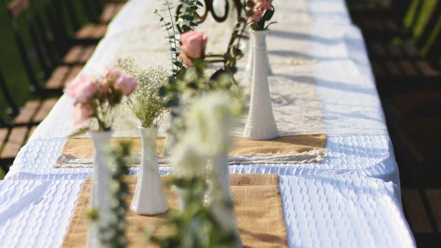 A beautifully set long table with white flowers and candles, ready for an event at the Tallman Hotel.