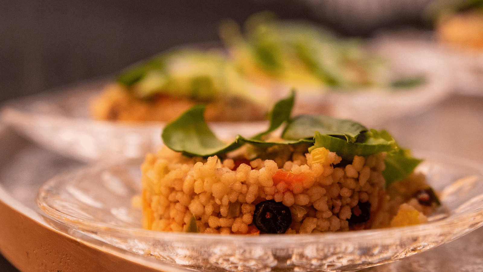 image of a dish made of rice served on a white china plate garnished with green veggies and herbs