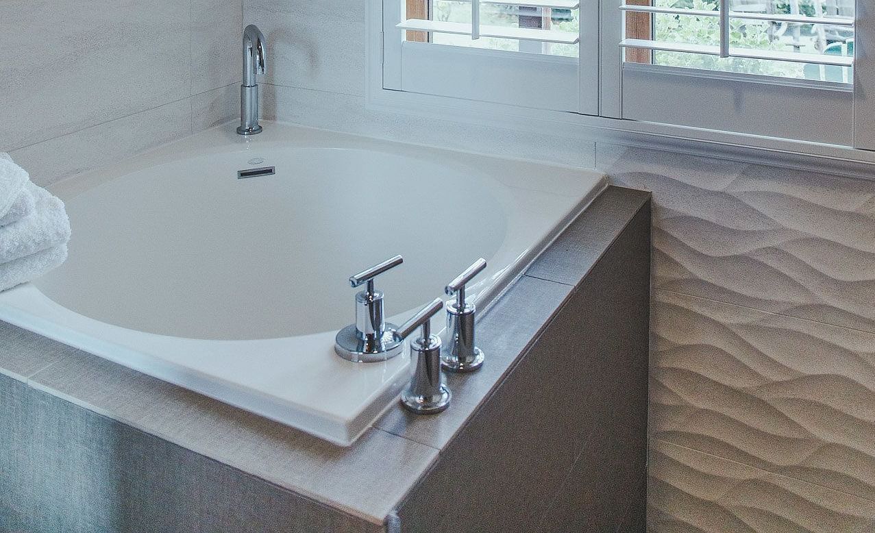 A bathroom with a soaking tub and natural light - Brewery Gulch Inn & Spa