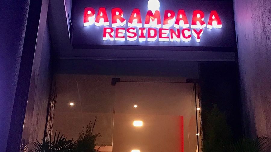 Night view of the entrance of Parampara Residency, Kushalnagar with Parampara Residency written on it.