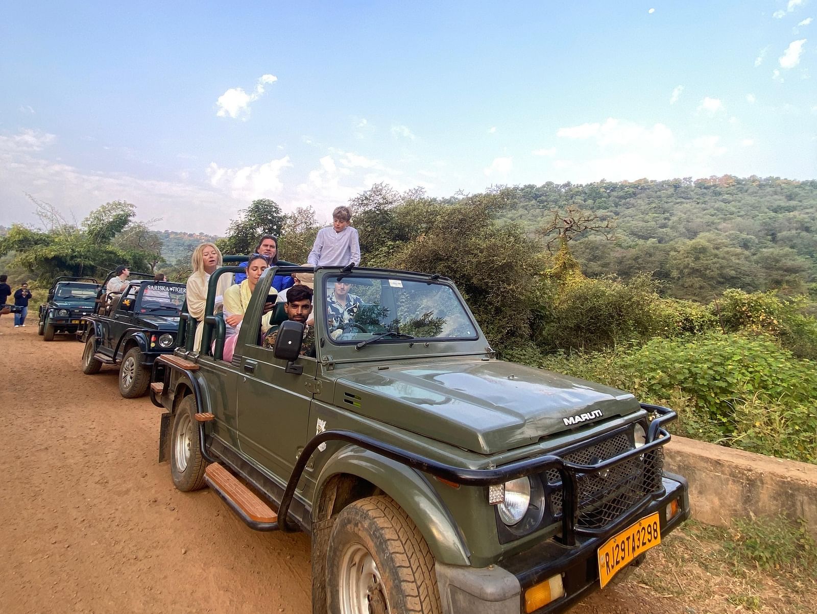 Image featuring few vehicles with the people in it, captured in the day time