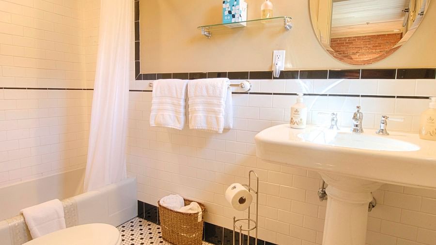 a bathroom featuring a bathtub in the corner along with a washbasin and a commode - Historic Tapoco Lodge