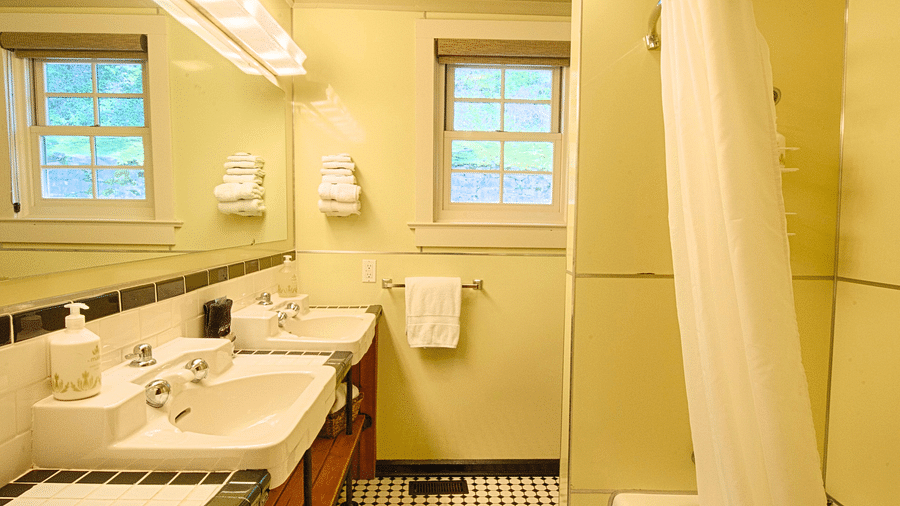 a bathroom with a bath tub and a wash basin placed right opposite to it - Historic Tapoco Lodge