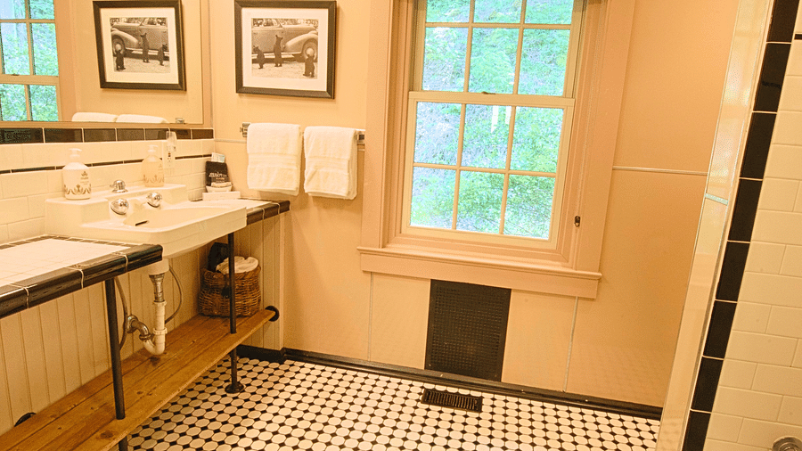 a brightly lit bathroom with beautiful tiles along with a window featuring the wash area - Historic Tapoco Lodge
