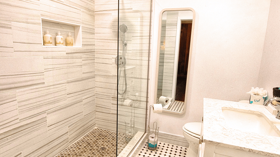 a bathroom featuring a full length mirror along with a wash basin right opposite to the shower area - Historic Tapoco Lodge