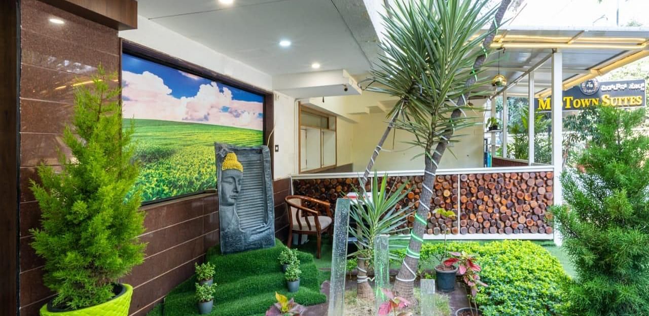 A beautifully landscaped outdoor area with a small fountain and greenery offers a refreshing escape at Lords Midtown Suites.