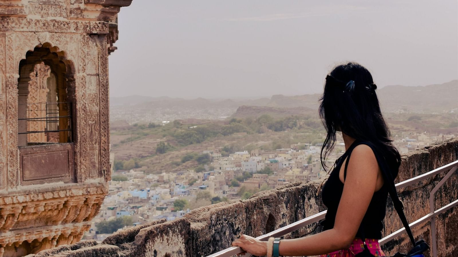 A woman looking out over the city of Jaisalmer from a balcony of Jaisalmer Fort in rajasthan