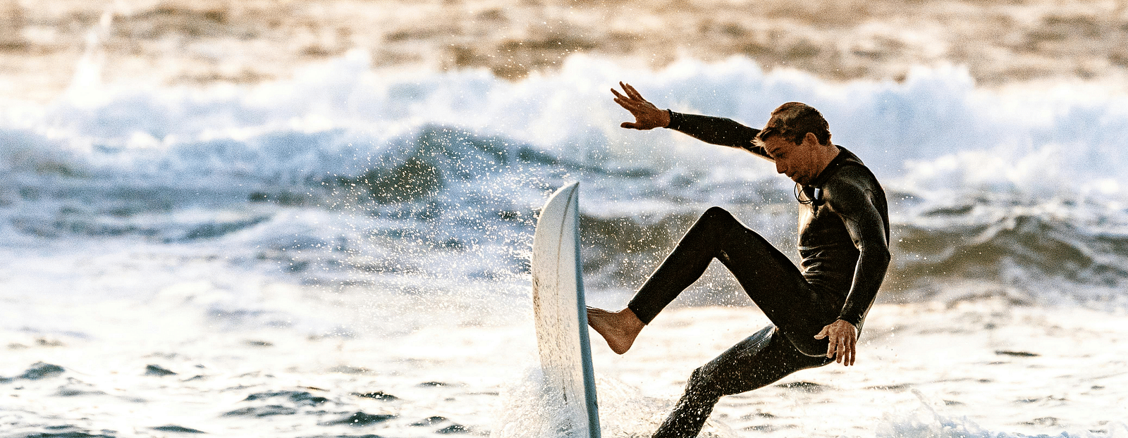 A man rides a wave on his surfboard in the open sea.