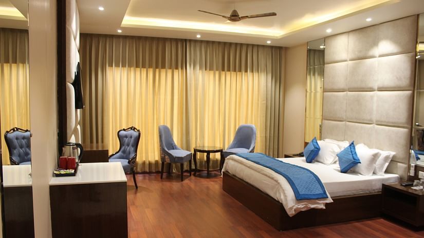 View of Deluxe room with bed and bedside tables seating area with windows and curtains  - Mastiff Hotel, Dalhousie