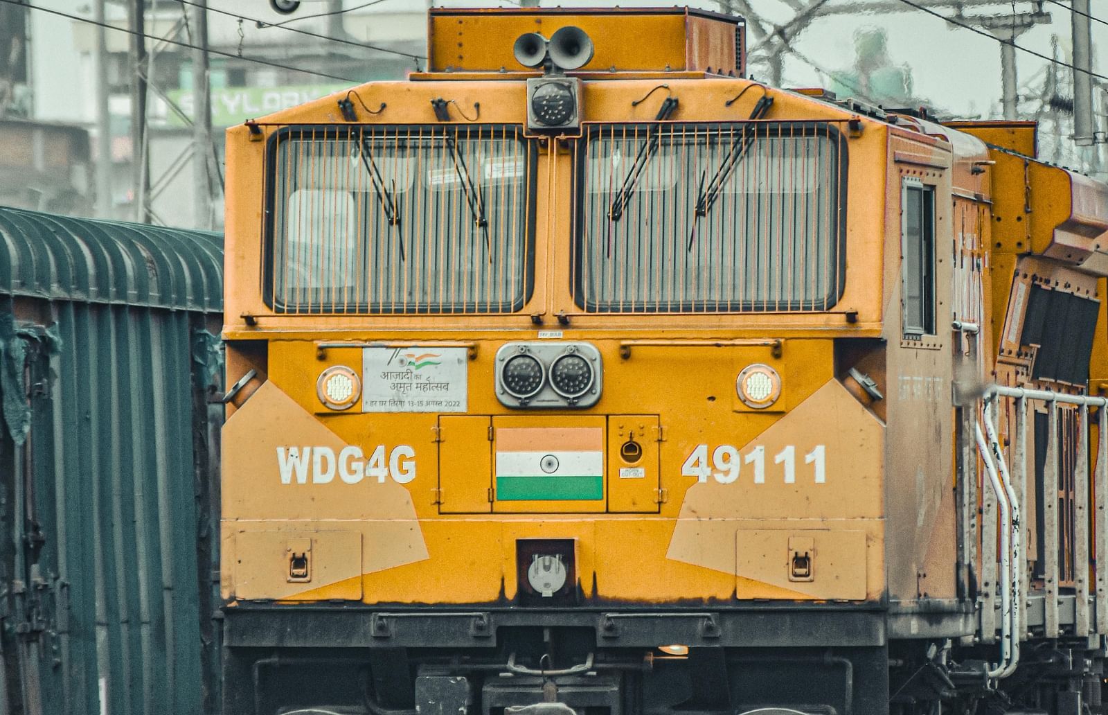 Yellow electric train engine on railway tracks at a station