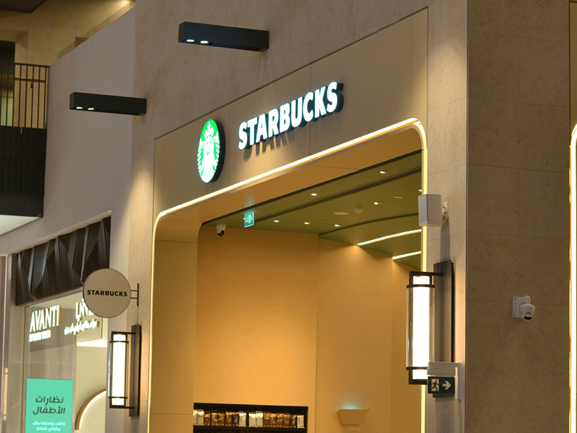 Entrance to Starbucks with the logo overhead with warm lighting