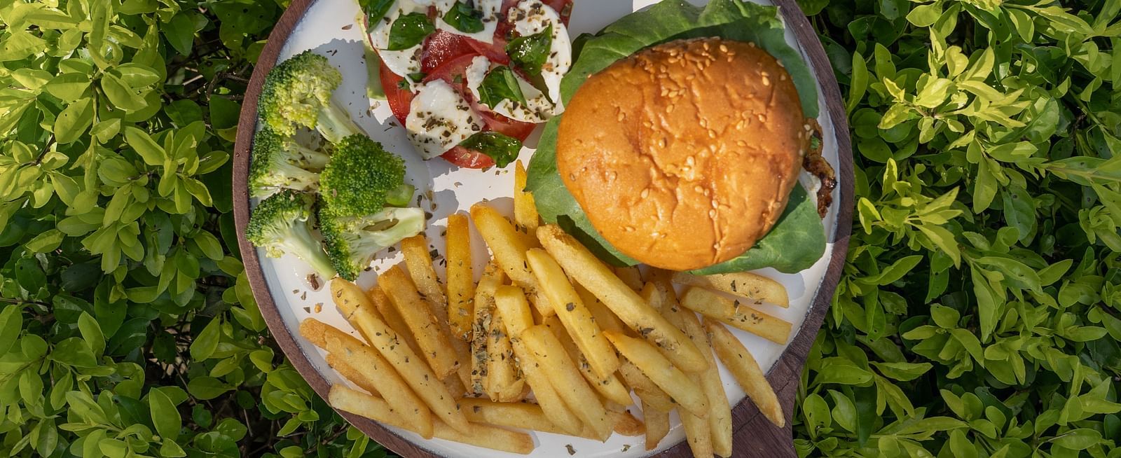an aerial view of a burger, fries, and other items kept on a bowl - neer ganga Resorts
