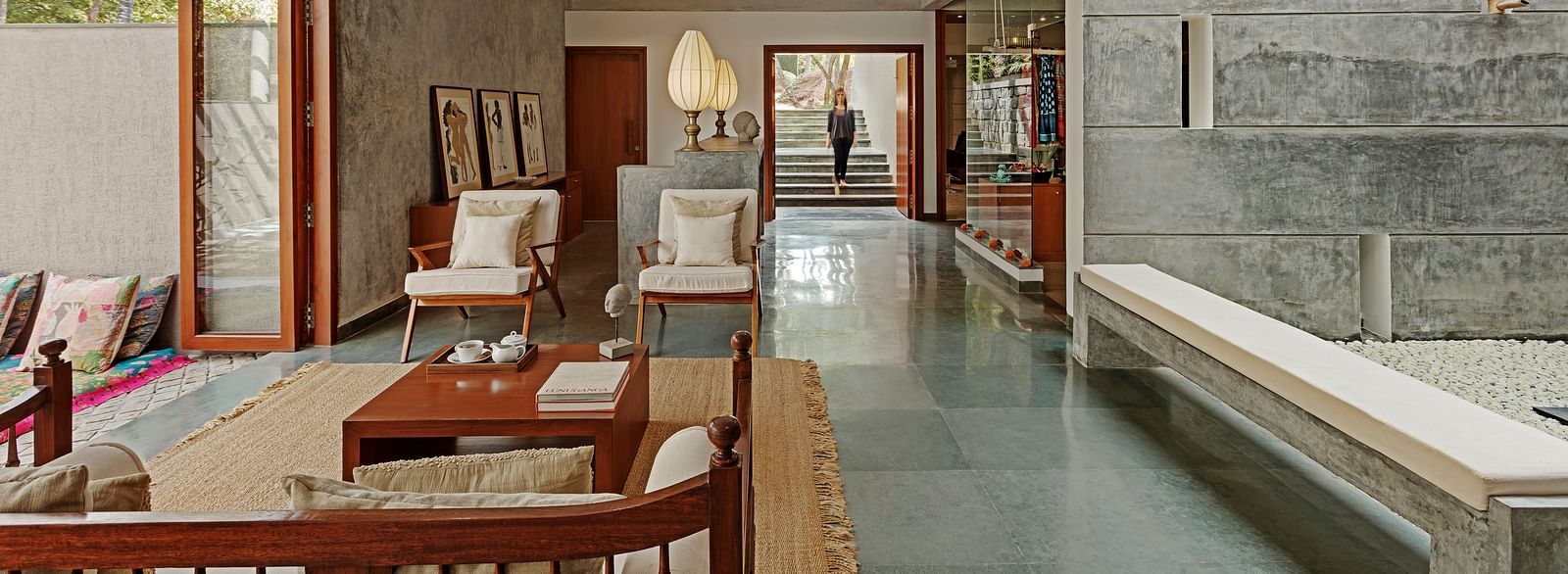 Long hallway with seating and a view of a garden, indoor setting - Shreyas Retreat