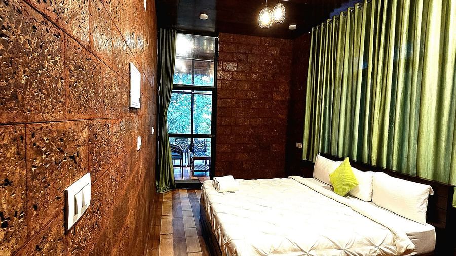 Inside view of the room with a cosy bed at Holistic Stay Eco Resort