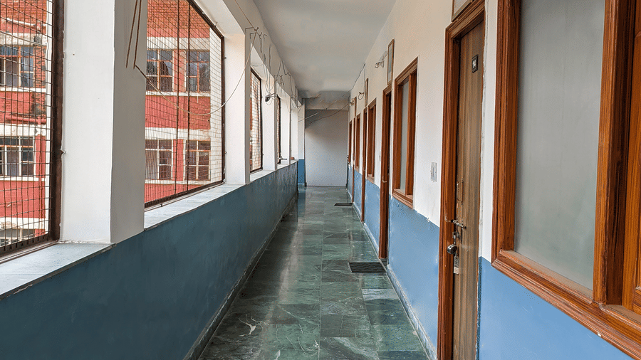 A hallway with bright lights and view of room doors on one side - Hotel Goverdhan, Agra