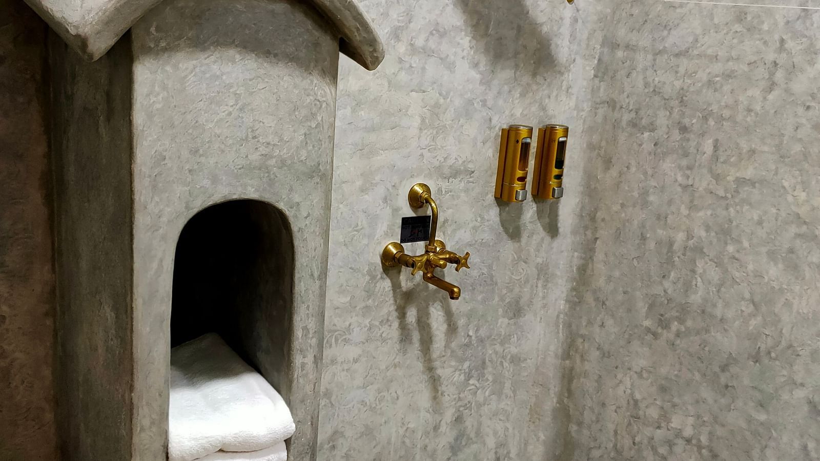 Yellowfin-washroom in grey theme, with a unique post box shaped place holder for keeping towels, a copper  bucket and all the furnishings in copper.