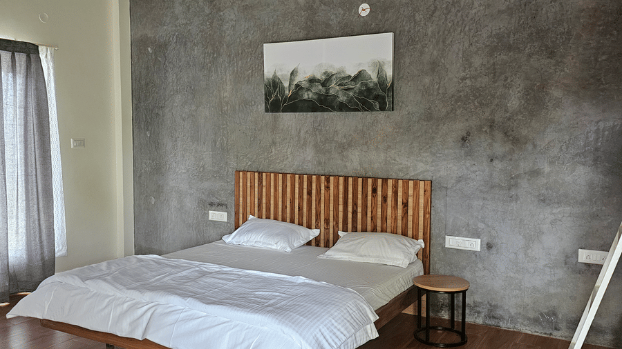 Cozy bedroom with a queen bed, wooden flooring, and minimalist interiors.