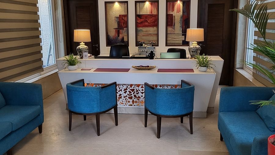 An image of a reception lobby featuring sofas, chairs, reception desk, and lights hanging from the ceiling - Inde Hotel Signature Tower Gurgaon